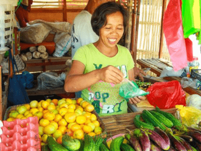 Judith smiling in her vegetable stall in the Philippines.