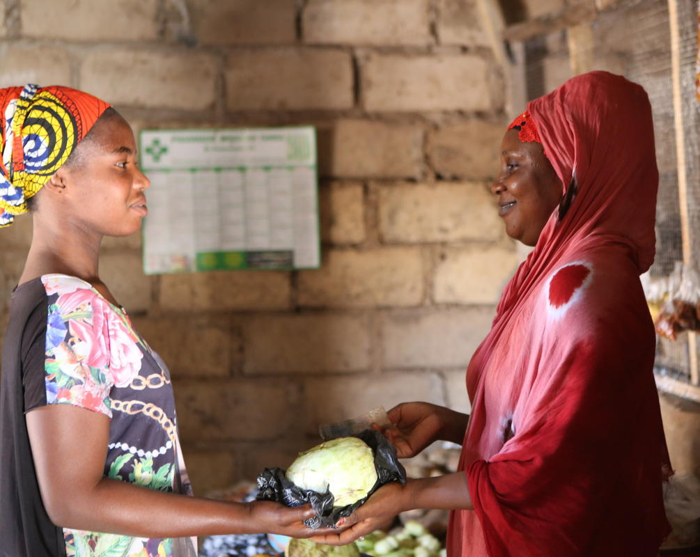 woman selling produce to another woman