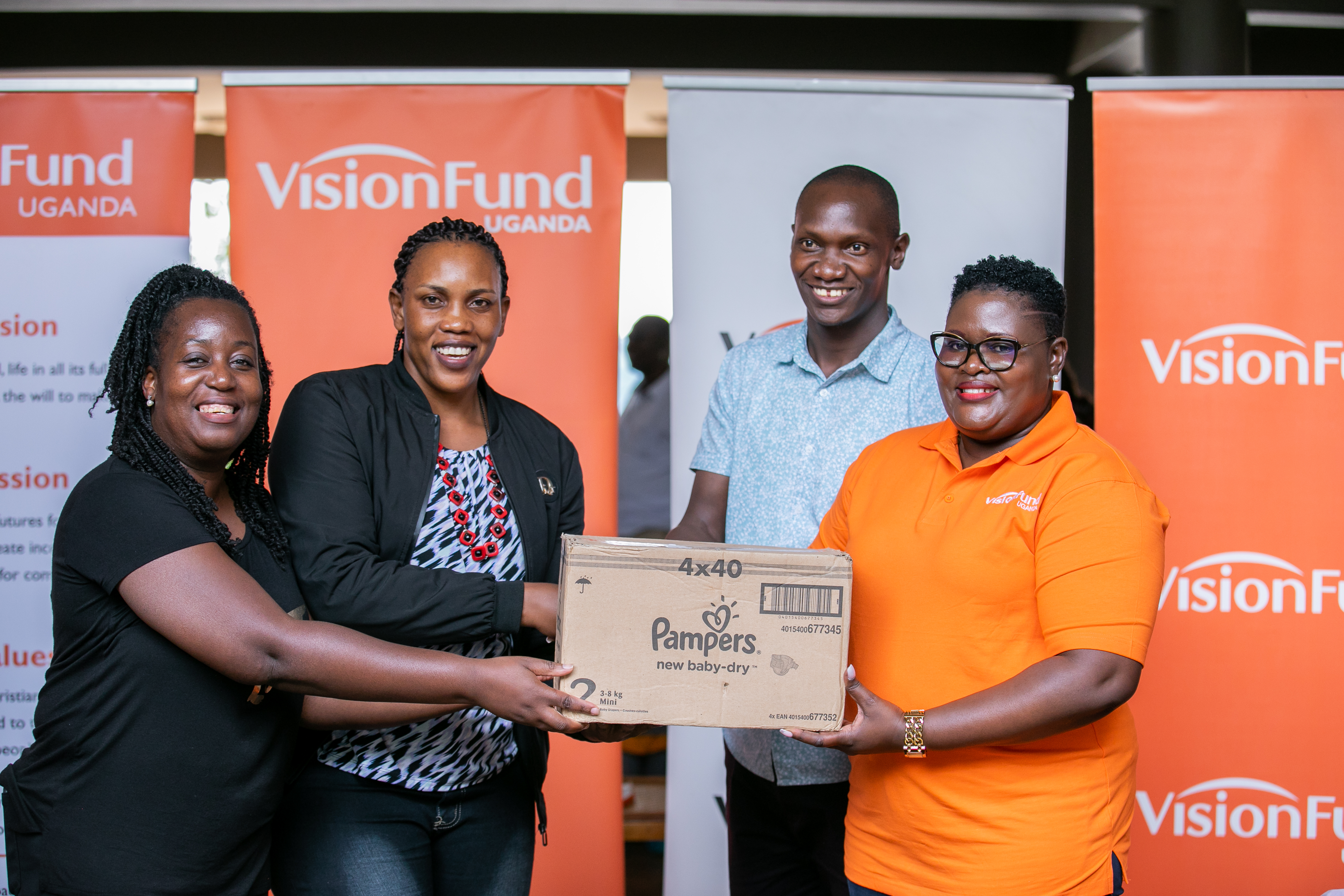 VisionFund Uganda CEO, Mercy Sande Ainomugisha hands over items to Watoto Leadership 