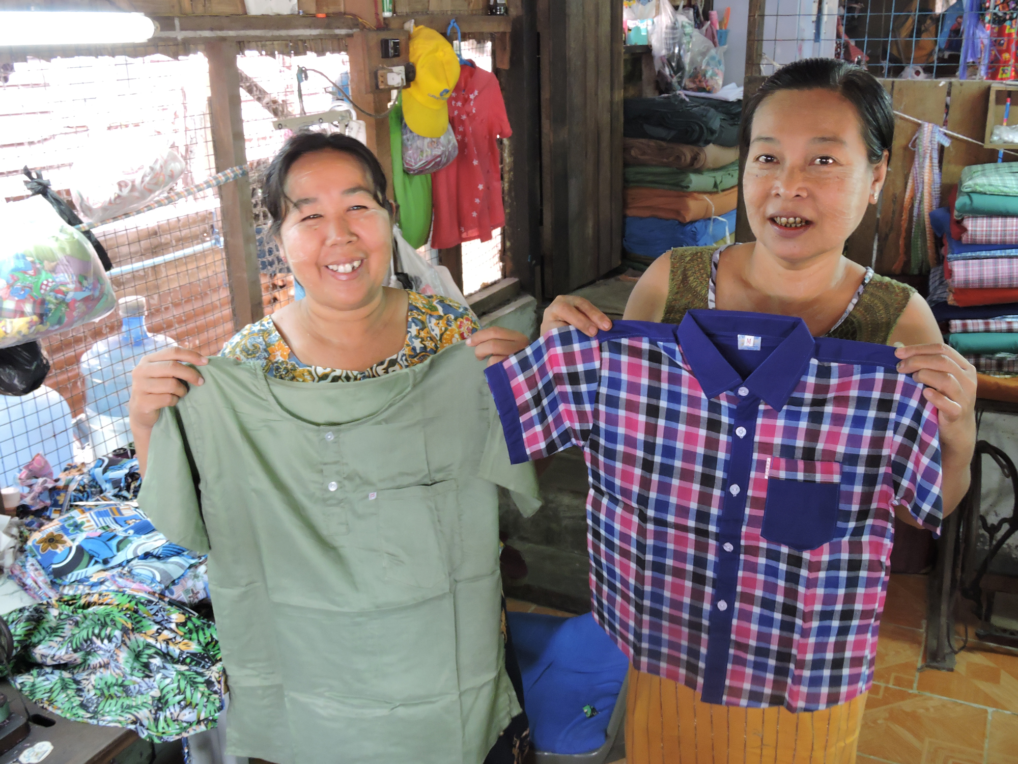 Woman and employee holding clothing they made