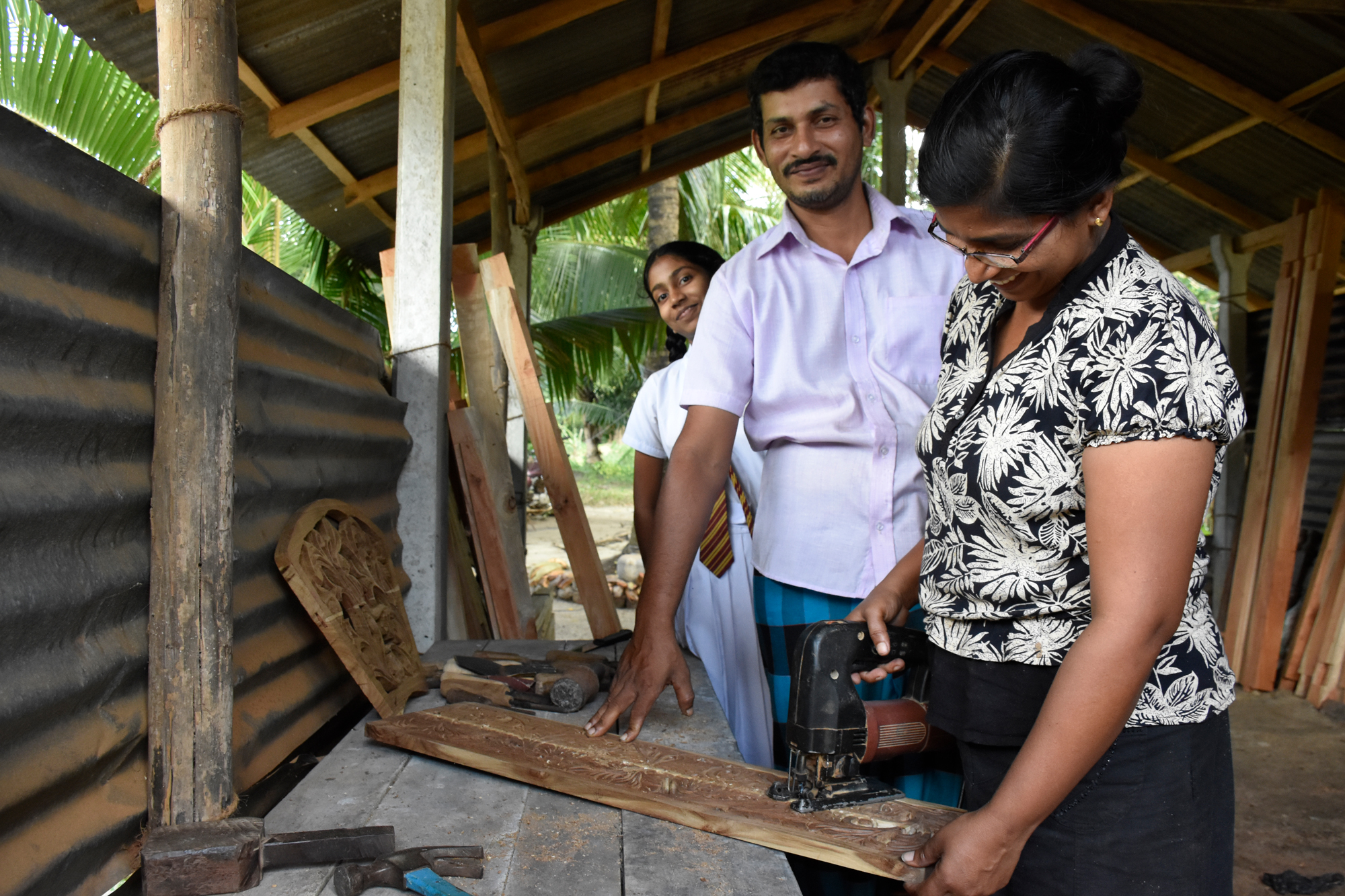 Wijayangani carving out a design while her husband Saman watches. 
