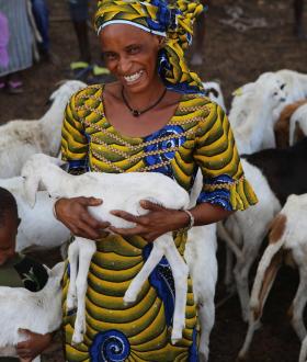 Woman in Senegal holding goat with child