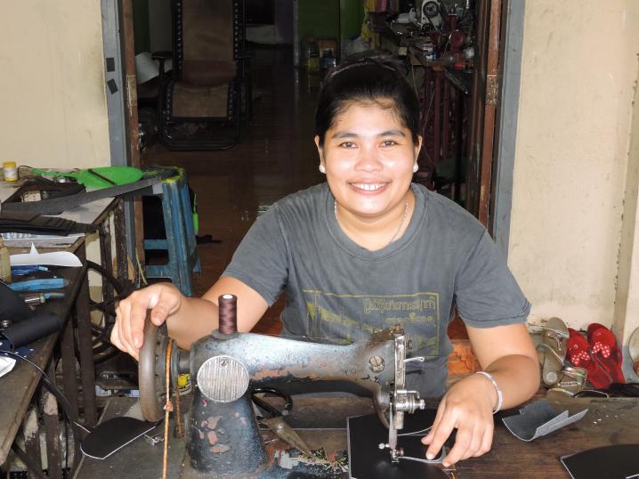 Women at sewing machine used to make shoes for the military in Myanmar