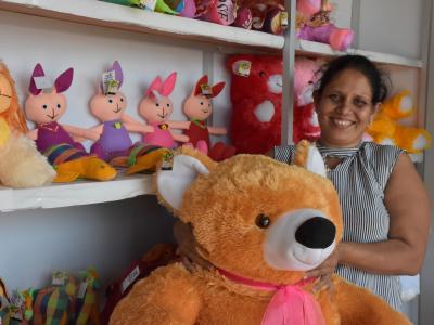 A single-mother of three, Thakshila (36 years) standing with a bear stuff animal in her store. 