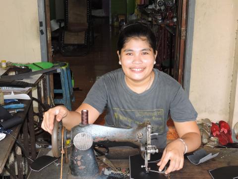 Women at sewing machine used to make shoes for the military in Myanmar
