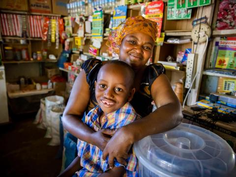 Fatuma and her son in her store that she got a loan to grow.
