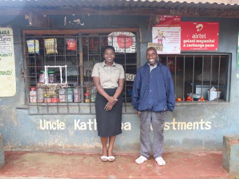 Feston and his VisionFund Malawi loan officer in front of his store. 