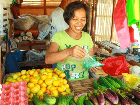Judith smiling in her vegetable stall in the Philippines.
