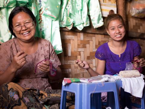 Myint Myint and her daughter working at their seamstress store.