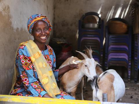 Woman sits with her goats
