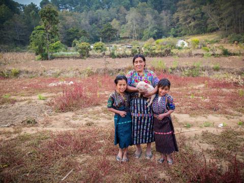 Mother with her two kids from Guatemala holding a piglet 