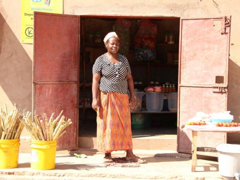 Woman stands outside her shop in Zambia