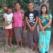 Family in Myanmar standing under a tree
