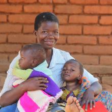 Mother holding two small children in Malawi