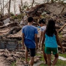 Children walk in the rumble in the aftermath of a typhoon